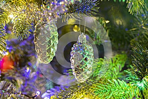 Close up of glass tree cones a christms tree decoration hanging on a fir branch