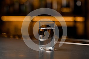 close-up glass of vodka on a bar counter in a blurred background