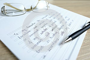 Close-up of glasses and a ballpoint pen on paper with a written will, the concept of a legal order on her movable and immovable