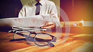 Close up glasses. newsletter concept businessman reading news the newspaper on desk in office