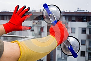 Close-up. Glazier holding the glass with a suction cup while installing the window