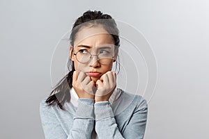 Close-up of gloomy offended young silly asian woman, sulking frowning upset, look left with envy or regret, have hard