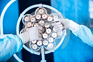 Close-up of gloved hands holding surgical scissors