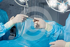 Close-up of gloved hands holding surgical scissors