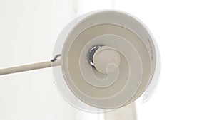 Close-up of glowing bulb with floor lamp. Media. Lamp with open round plafond included on white background. Lighting