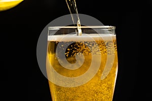 Close-up of goblets with pouring beer