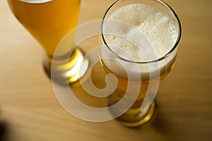 Close-up of goblets with pouring beer o