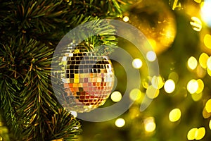 Close Up gold balls of Christmas tree decorations on abstract light golden bokeh background.