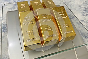 Close up gold bars on precision scales