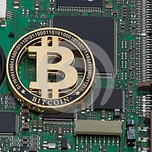 Close-up of gold bit coin, computer circuit board with bitcoin processor and microchips. Electronic currency, internet finance ryp