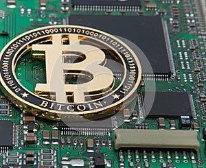 Close-up of gold bit coin, computer circuit board with bitcoin processor and microchips. Electronic currency, internet finance ryp