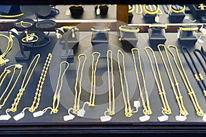 Close-Up of Gold Necklaces, Rings, and Chains in Beauty Store Window