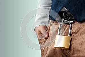 Close-up of a gold padlock hanging from a man`s belt. The concept of marital fidelity, celibacy, treason, chastity belt photo