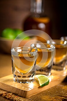 Close up of gold Tequila shots flight with cut limes and salt photo