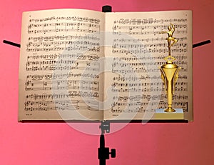 Close up of gold trophy and music note stand.