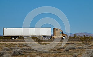CLOSE UP: Gold truck speeds along the interstate highway crossing a desert