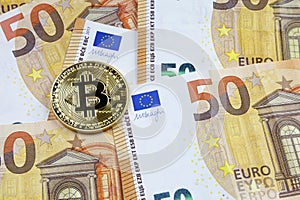 Bitcoin on a stack of 50 Euros