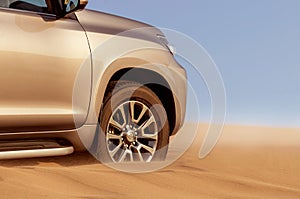 Close up of a golden car stuck in the sand in the Namib desert