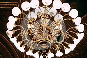 Close-up of a golden chandelier in the dark.