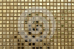 Close-up of golden-colored square glass tiles covering the bathroom wall texture as a background