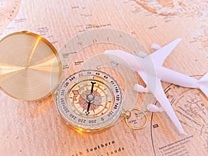 Close up of golden compass on vintage map,travel concept