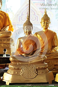 Close-up of golden meditating buddha statues