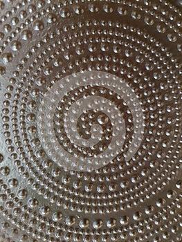 Close-up of a golden metal surface, mandala shape with balls of various sizes forming various circles. photo
