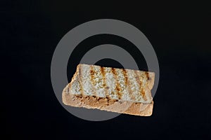 Close up of golden slice of toast on black background