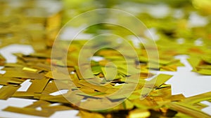 Close-up, golden spangles from crackers, festive tinsel, decorations.