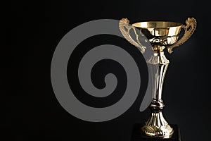 Close up of Golden trophy over black background. Winning awards with copy space for text and design.