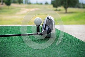 Close-up of a golf ball and a golf wood on a driving range