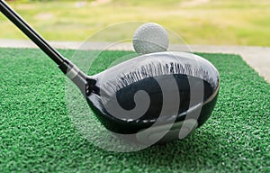 Close-up of a golf ball and a golf wood on a driving range