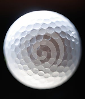 Close-up of a golf ball over dark background