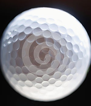 Close-up of a golf ball over dark background