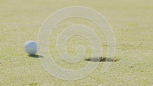 Close up of a golf ball rolling next to the hole. Missing the shot