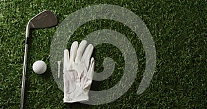 Close up of golf club, ball and glove on grass, copy space, slow motion