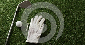 Close up of golf club, ball and glove on grass, copy space, slow motion