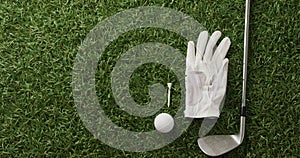 Close up of golf club, ball and glove on grass, copy space, slow motion