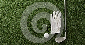 Close up of golf club, ball and glove on grass, copy space, slow motion