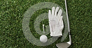 Close up of golf club, ball and glove on grass, copy space, slow motion