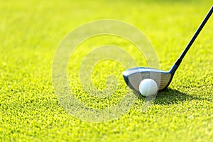 Close up Golf club hitting golf ball along fairway towards green with copy space,