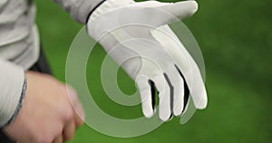 Close up of golfer putting on sports glove