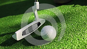 Close-up of golfer using putter to sink short putt into hole