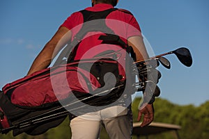 Close up of golfers back while walking and carrying golf bag