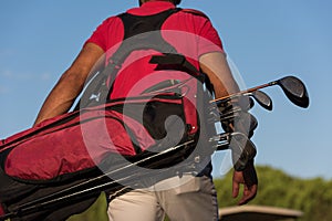 Close up of golfers back while walking and carrying golf bag