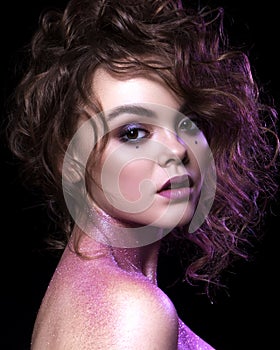 Close up of a gorgeous woman with creative fashion make up: glitters and glamour shine. Curly evening hairstyle. look