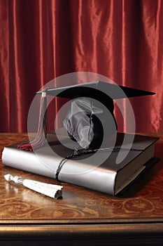 close-up of a graduation cap and diploma on a table