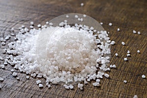 Close-up of Grains of Seasalt on a Dark Wooden Chopping Board photo