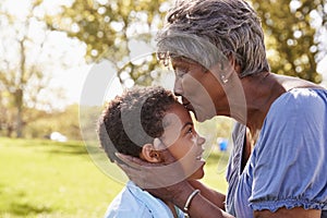 Close Up Of Grandmother Kissing Grandson In Park