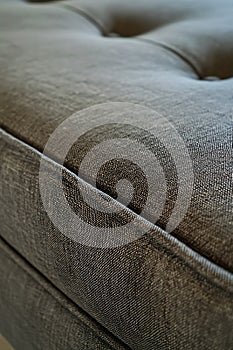 A close up of a gray couch with a black and white pattern